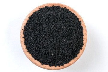 nigella seeds in wooden bowl isolated on white background.