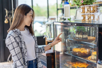 woman choosing cake in a cafe