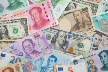 Flat lay or top view of world international banknotes vary countries background. US Dollar, Chinese yuan, Japanese yen, Euro, Indian rupee, Thai baht. Concept of Forex or global financial economic.