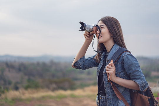 tourist woman taking photo with her camera in nature