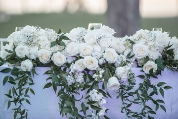 Obraz na płótnie Canvas White roses floral bouquet on white table