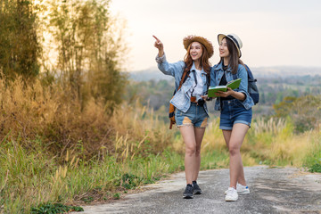 Fototapeta premium two woman searching direction on location map while traveling