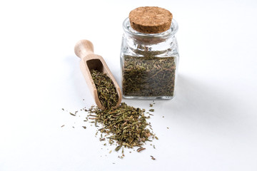 thyme herb in wooden scoop and jar on isolated on white background