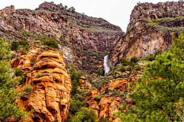 Waterfall coming down the colorful sandstone mountains in Oak Creek Canyon along Arizona SR89A between Sedona and Flagstaff in northern Arizona, United States of America