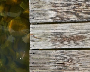 Close up of wooden dock with rocks under water