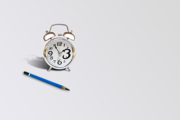 Time and Idea Concept : Blue pencil and silver alarm clock place on gray background.
