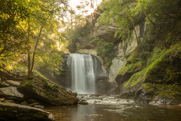 Fototapeta na wymiar Smooth waterfall in woods with rocks