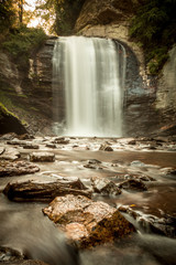 Obraz premium Smooth waterfall in woods with rocks