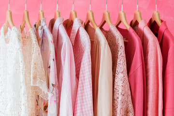 Pink colored women clothes hanging in row on rack
