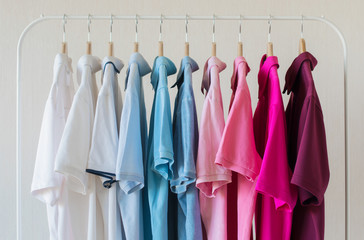 Man's polo shirts hanging in row in rack