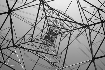Abstract pattern from bottom view of high voltage pole power transmission tower with clear sky...