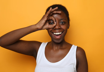  Beautiful happy young african woman  isolated over yellow  background 