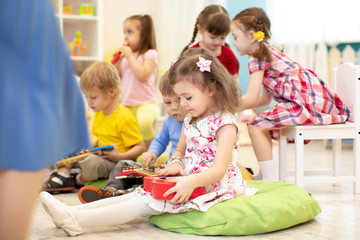 Group of preschooler kids play with musical toys at kindergarten