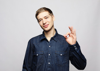 cheerful young man showing okay gesture