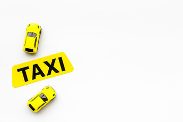 Taxi concept. Yellow service sign text taxi near car toy on white background top view space for text