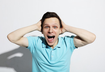 young man celebrating victory over white background