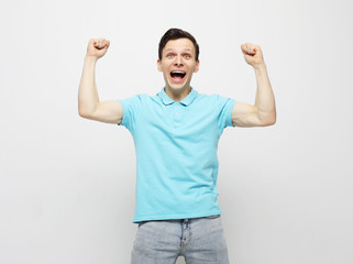 Fototapeta premium young man celebrating victory over white background
