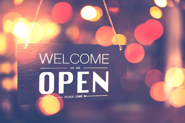 Open sign hanging front of cafe with colorful bokeh light abstract background.