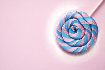 Lollipop colored striped, pink and purple, on a pink background. Valentine's day. March 8. Women's day. Children's holiday. Children. Child