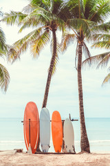 Surfboard and palm tree on beach background. - obrazy, fototapety, plakaty