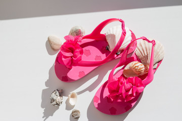 Fashionable sandals, seashells on white background, top view, flat lay.summer pink Shoes for kids, Children's slippers, beach fashion for baby, bright Sandals shoes,holiday concept