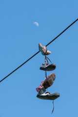 shoes on a string against sky with moon