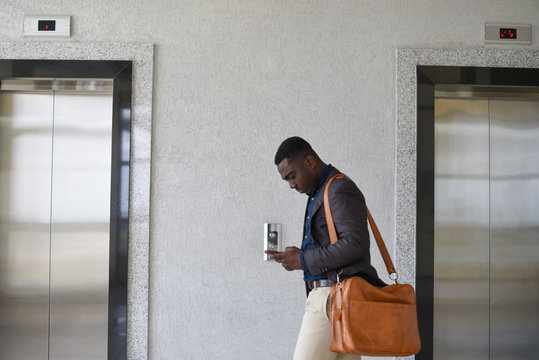 Young professional man texting while walking