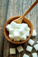 Close up of sugar cube on wooden spoon.