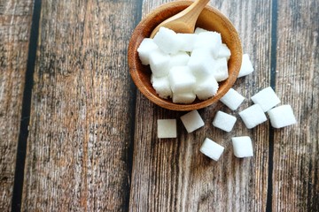 Close up of sugar cube on wooden spoon.