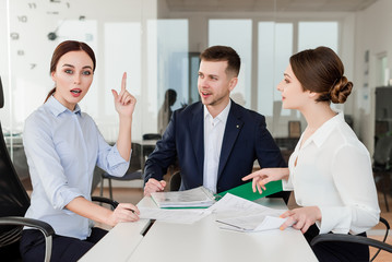 Fototapeta premium Successful young employees working together excited about new idea they have. Business concept of co-workers in the office space.