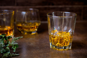 glasses of whiskey with ice cubes  on  bar.