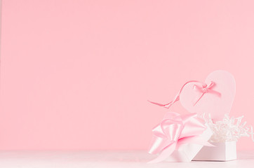 Fototapeta na wymiar Valentine days background - elegant pastel pink decorative heart with ribbon and gift box on white wood board, copy space.