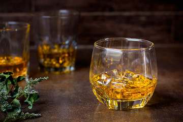 glasses of whiskey with ice cubes  on  bar.