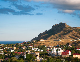 Panorama of the city of Koktebel on the background of mountains and the sea. Crimea
