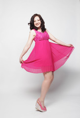 Full length portrait of happy beautiful woman in pink dress