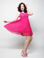 Full length portrait of happy beautiful woman in pink dress