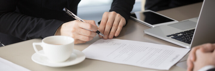 Closeup horizontal view of businesswoman hands signing contract lawful paper