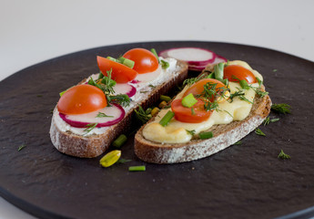 Multigrain toast bread with melt gouda or kaseri cheese and small tomatoes radish and green onion on top