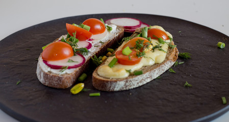 Multigrain toast bread with melt gouda or kaseri cheese and small tomatoes radish and green onion on top