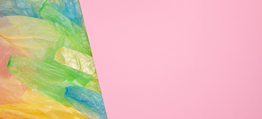 Obraz premium Multicolored single use plastic shopping bags with blank pink background for text or image