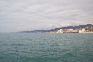 Fototapeta premium Resorts and holiday homes on the Black sea in the vicinity of Sochi. Landscapes villages Uch-Dere, Loo and Dagomys on a cloudy day from the sea