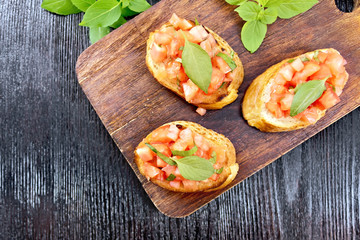 Bruschetta with tomato and basil on board top