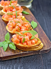 Bruschetta with tomato and basil on table