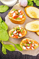 Bruschetta with tomato and cheese on board top