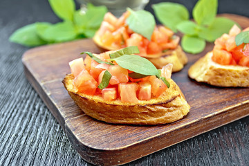 Bruschetta with tomato and basil on wooden board