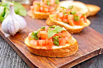 Bruschetta with tomato and spinach on board