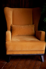Cozy old mustard-colored armchair. Interior in retro style.