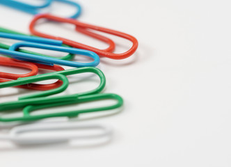 Colorful paper clips on white background soft-fokus
