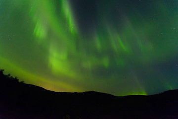 Fototapeta na wymiar Northern lights at night over the hills.Aurora in the fall.