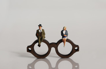 Miniature people and miniature glasses. The concept of stereotypes about masculinity and femininity...